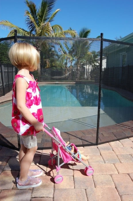 Girl and a stroller standing by a pool